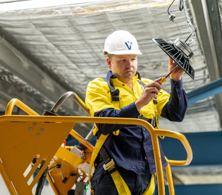 Level Electrical technician completing a commercial lighting installation in New Zealand, representing Level Group NZ’s national plumbing, electrical and energy capability.