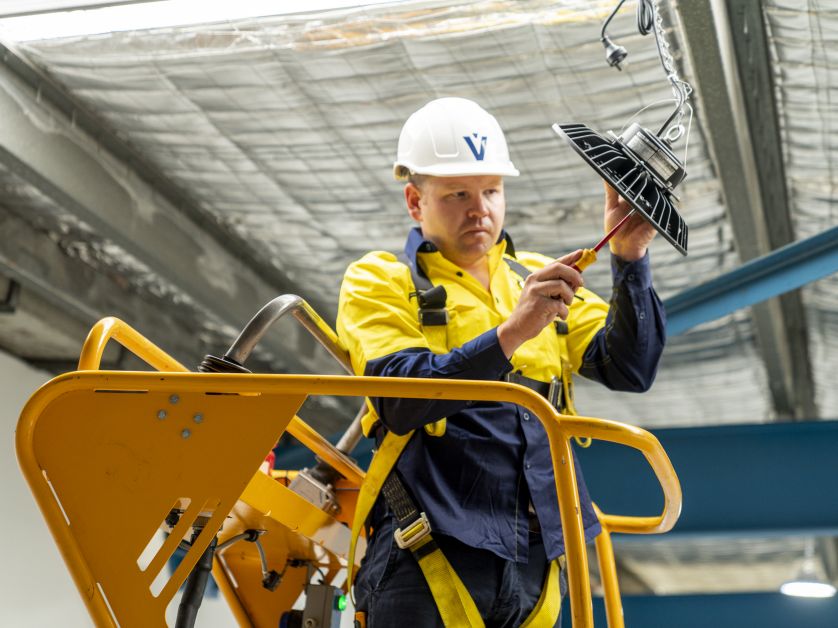 Level Electrical technician completing a commercial lighting installation in New Zealand, representing Level Group NZ’s national plumbing, electrical and energy capability.