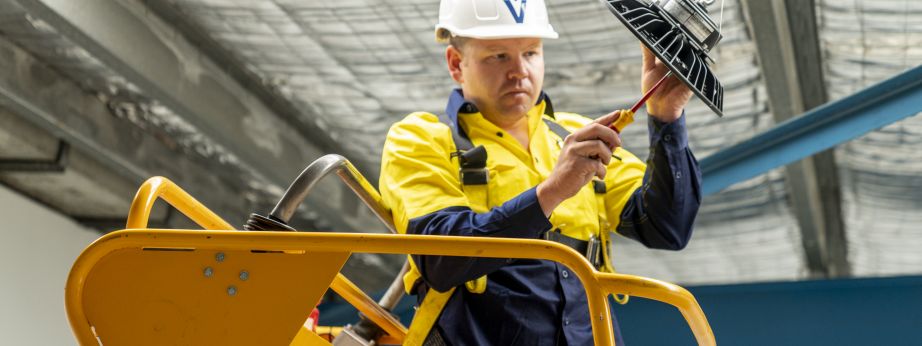 Level Electrical technician completing a commercial lighting installation in New Zealand, representing Level Group NZ’s national plumbing, electrical and energy capability.