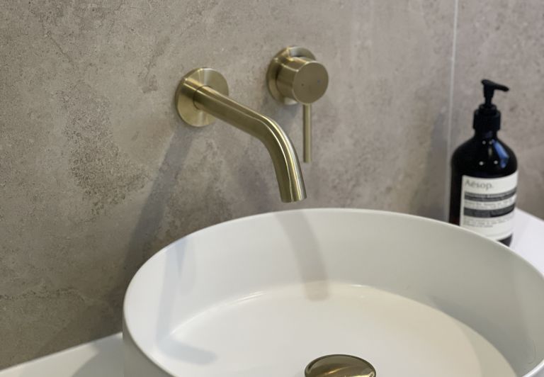 Modern bathroom renovation featuring a brushed brass tap and vessel sink completed by Level Plumbing Howick