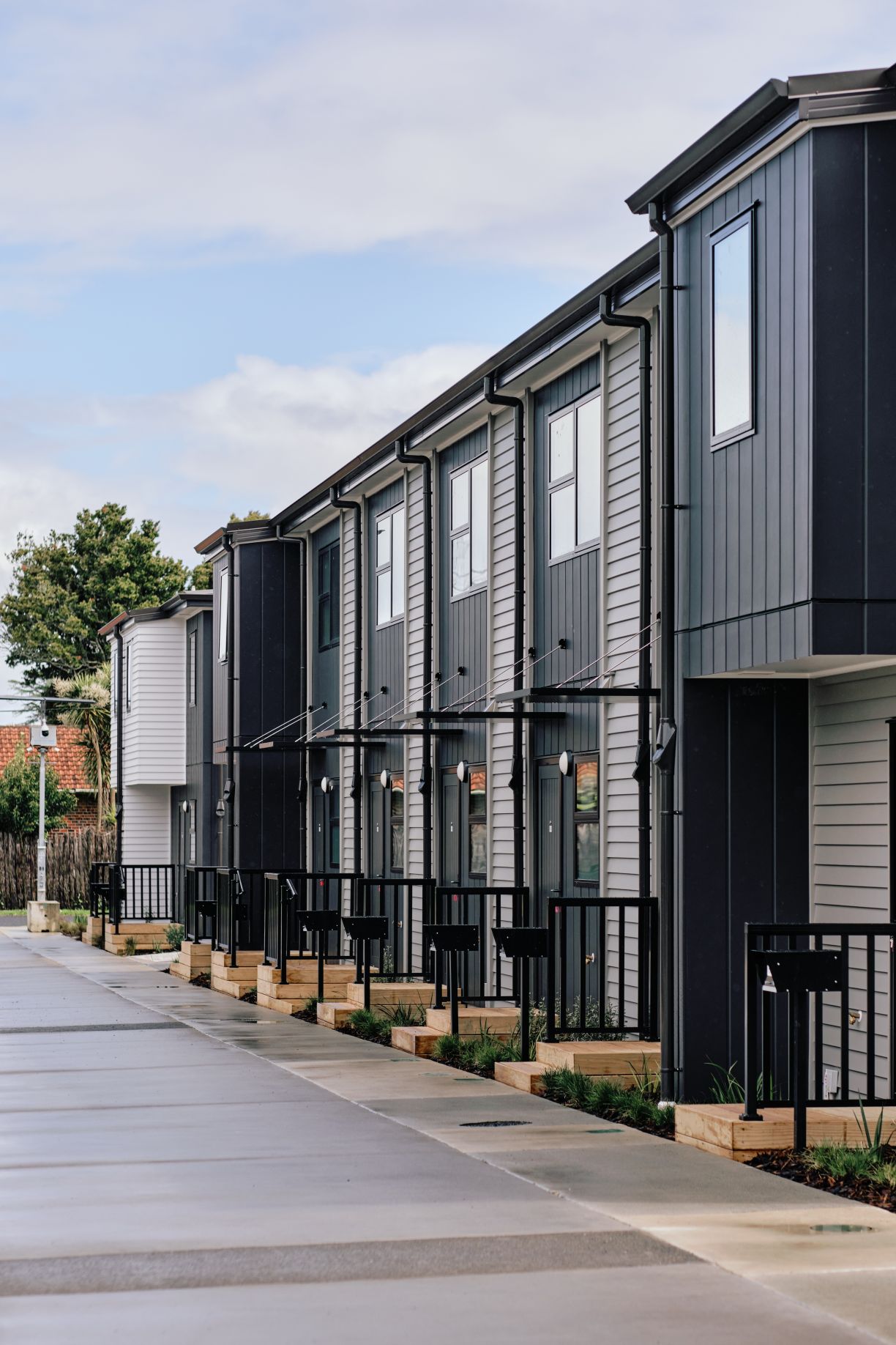Exterior drainage systems and downpipe installations along a multi-unit housing development in Howick