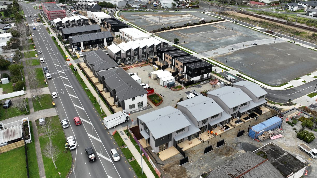 High-angle aerial shot of a multi-unit housing subdivision under construction with main line drainage installation