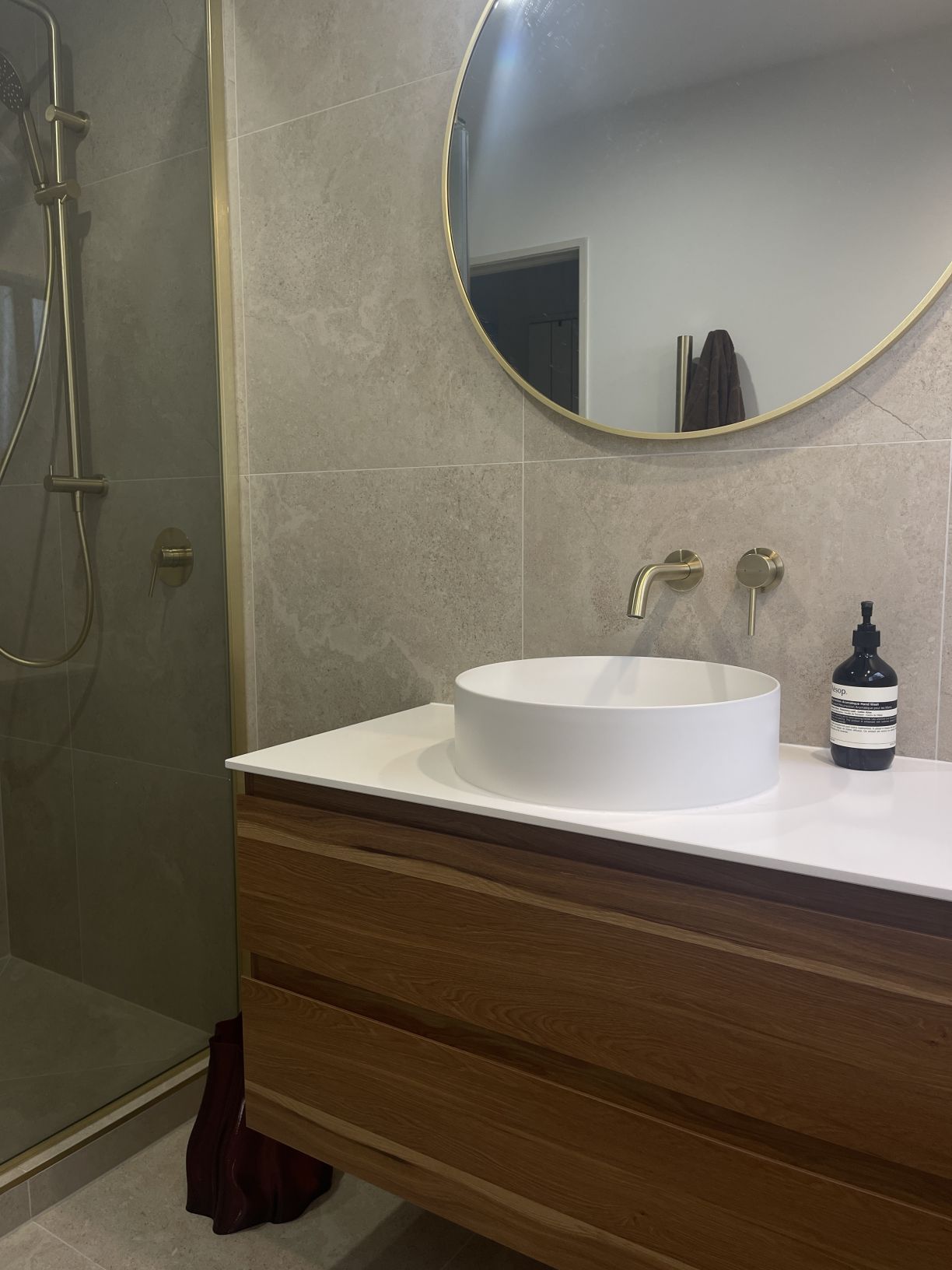 Full modern bathroom renovation featuring floating timber vanity, brass fixtures, and glass shower installed by Level Plumbing Howick