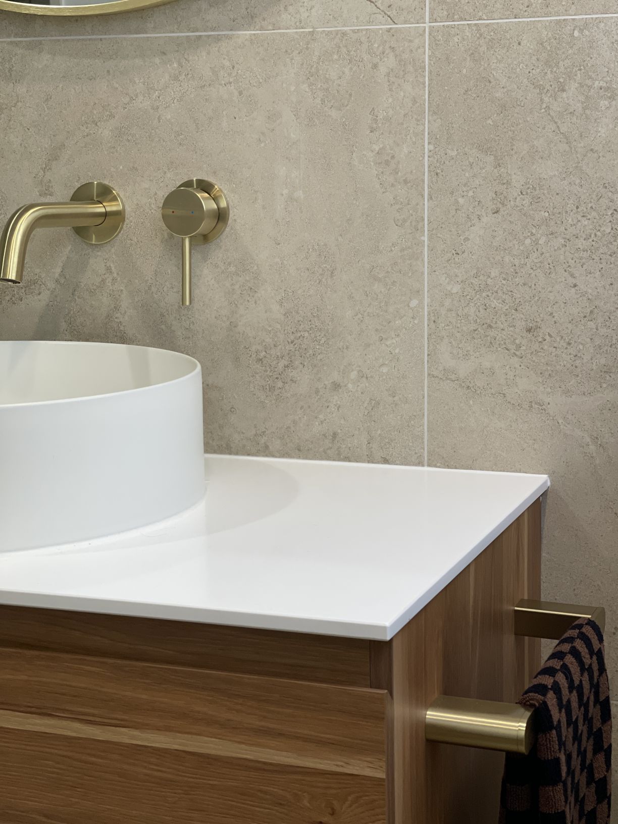 Modern timber vanity and brushed brass towel rail installed by Level Plumbing Howick
