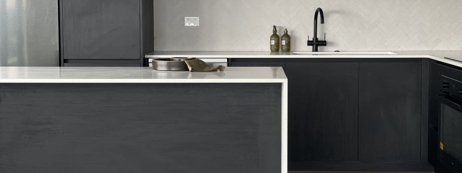 Matte black gooseneck kitchen mixer tap and undermount sink installed in a modern kitchen renovation by Level Plumbing Howick.