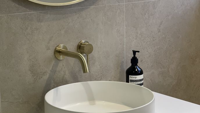 Clean modern vanity top with white vessel sink and brushed brass tapware by Level Plumbing Howick