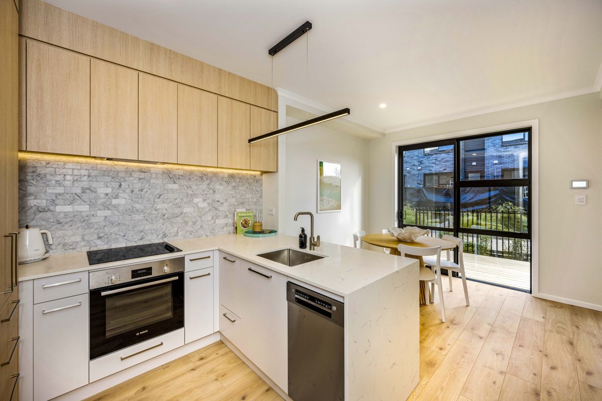 Modern kitchen island with undermount sink and mixer tap installed in a multi-unit townhouse development