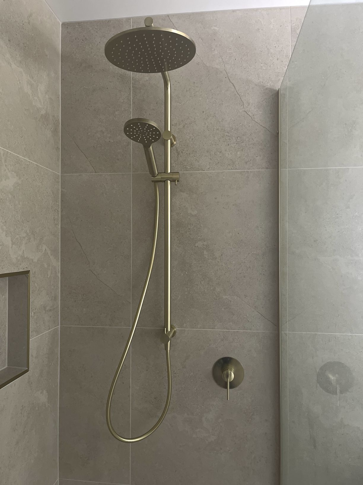 Brushed brass rain shower head and hand shower installation by Level Plumbing Howick