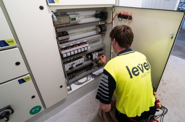 Level Electrical Ashburton technician working on electrical control panel at dairy shed in Banks Peninsula