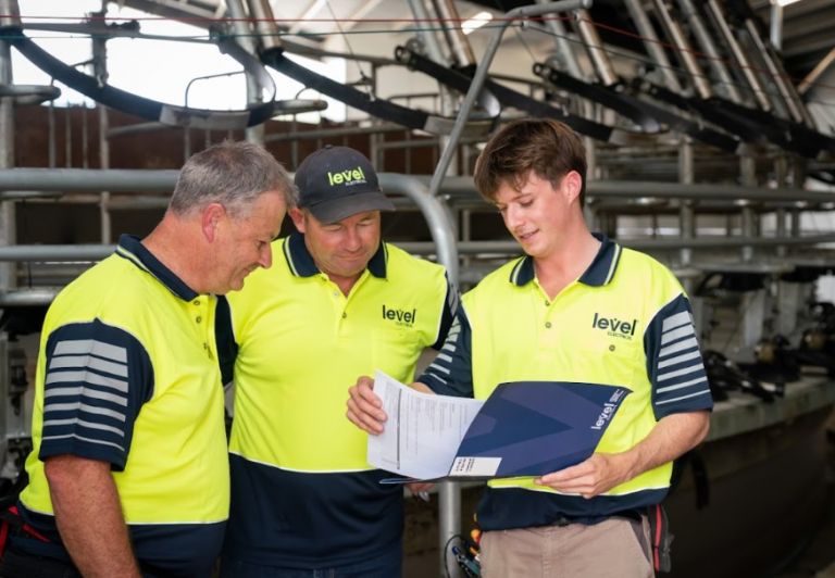Level Electrical Ashburton team reviewing project plans at dairy shed installation in Banks Peninsula