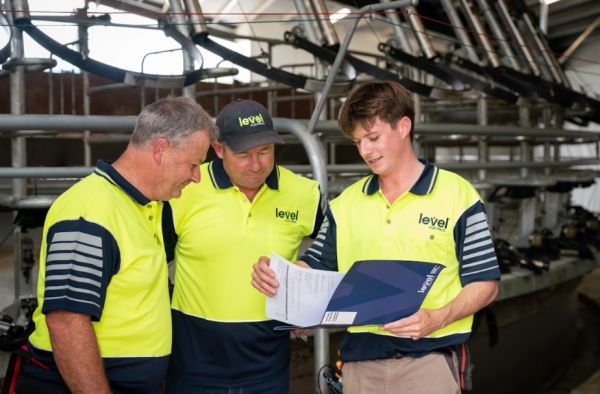 Level Electrical Ashburton team reviewing project plans at dairy shed installation in Banks Peninsula