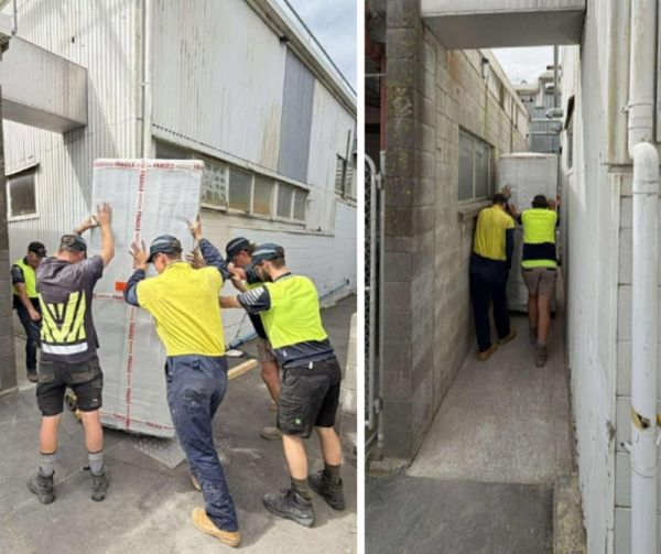 Team installing electrical switchboard through narrow access at McCain food processing facility in Timaru